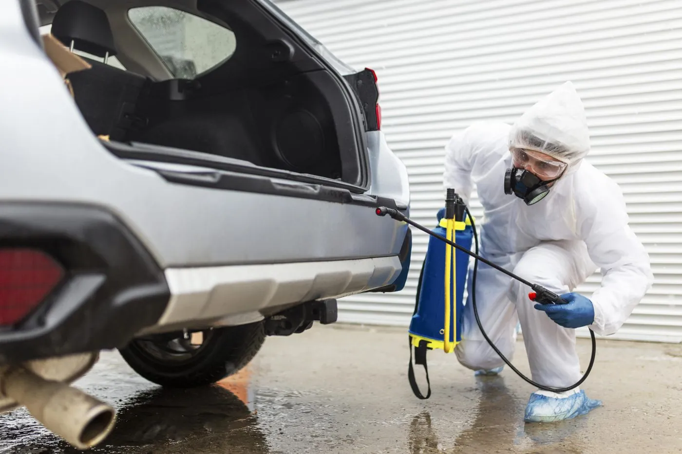 Technician disinfecting a car interior