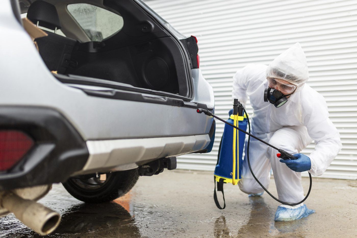 Technician disinfecting a car interior
